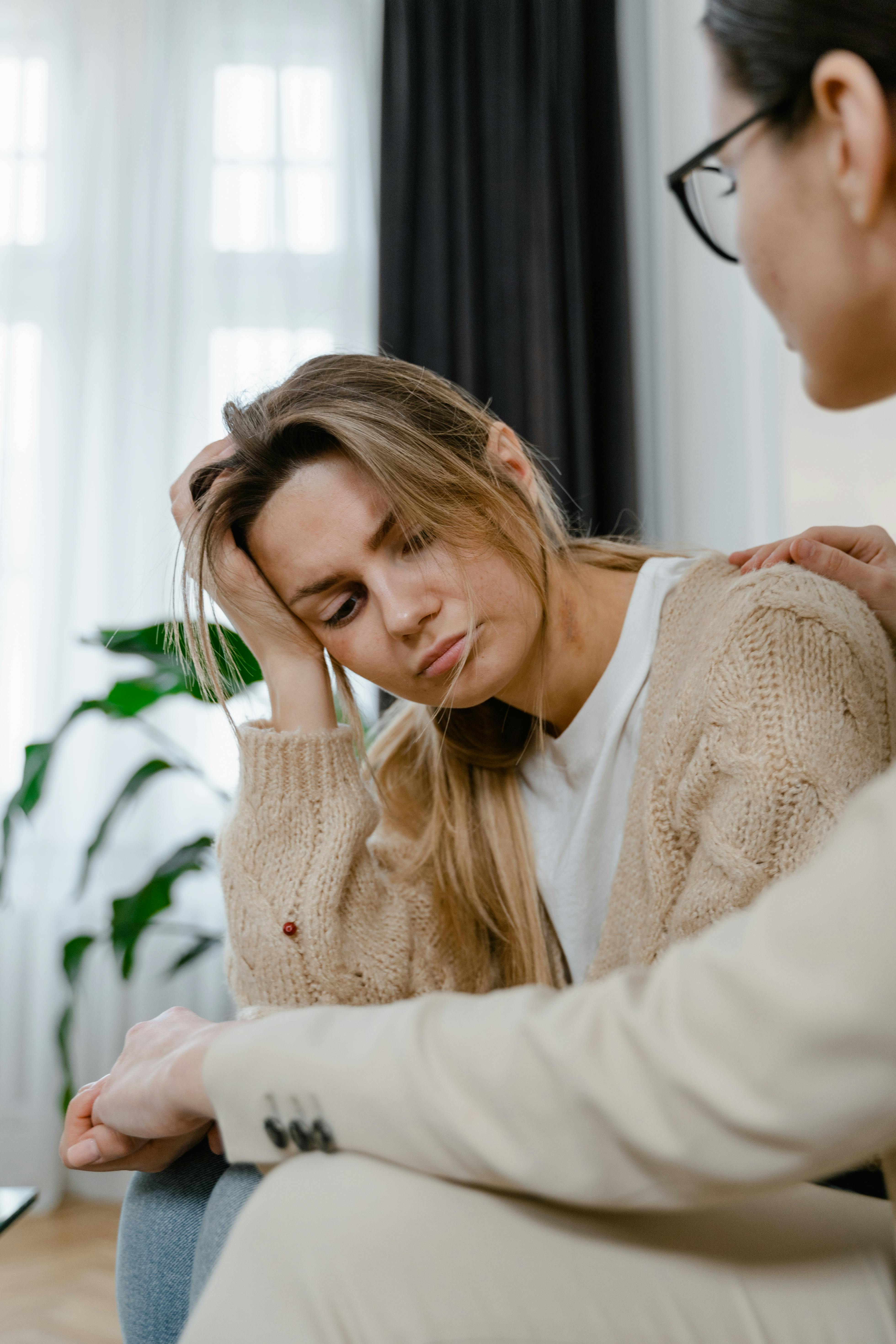 a sad woman sitting on a sofa