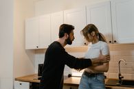 Man and Woman Standing in Front of Kitchen Cabinet