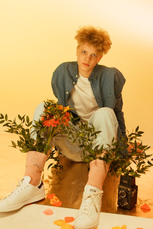 Photo of a Boy with Curly Hair with Green Leaves in His Socks