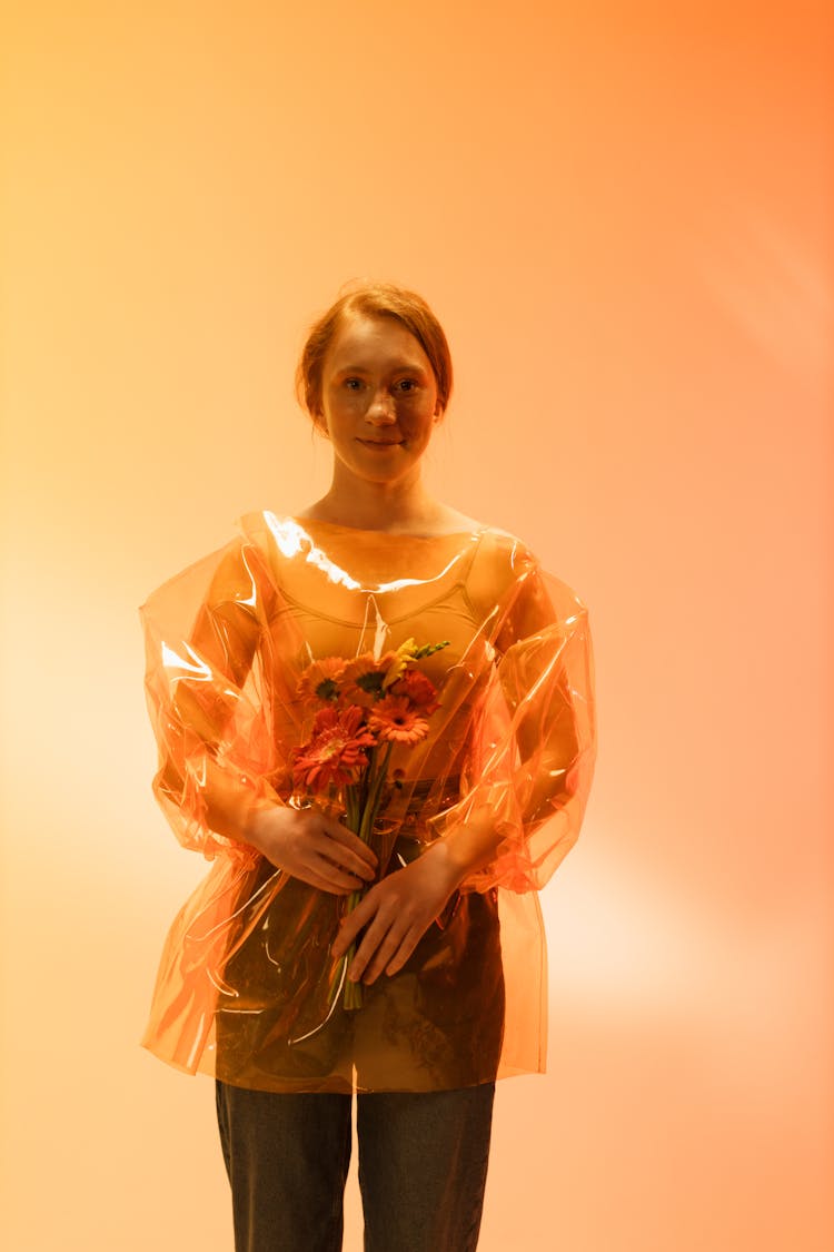 Woman Wearing A Clear Plastic Top Holding A Bunch Of Flowers