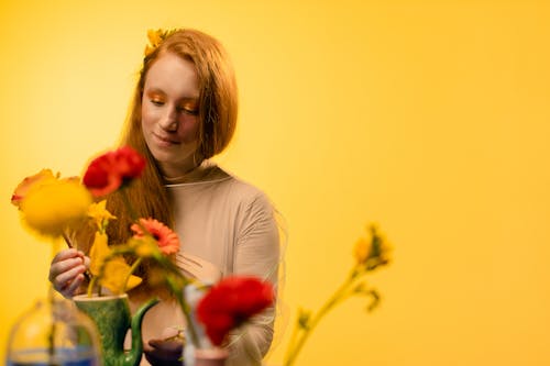 Photograph of a Girl in a Brown Top Looking at Flowers