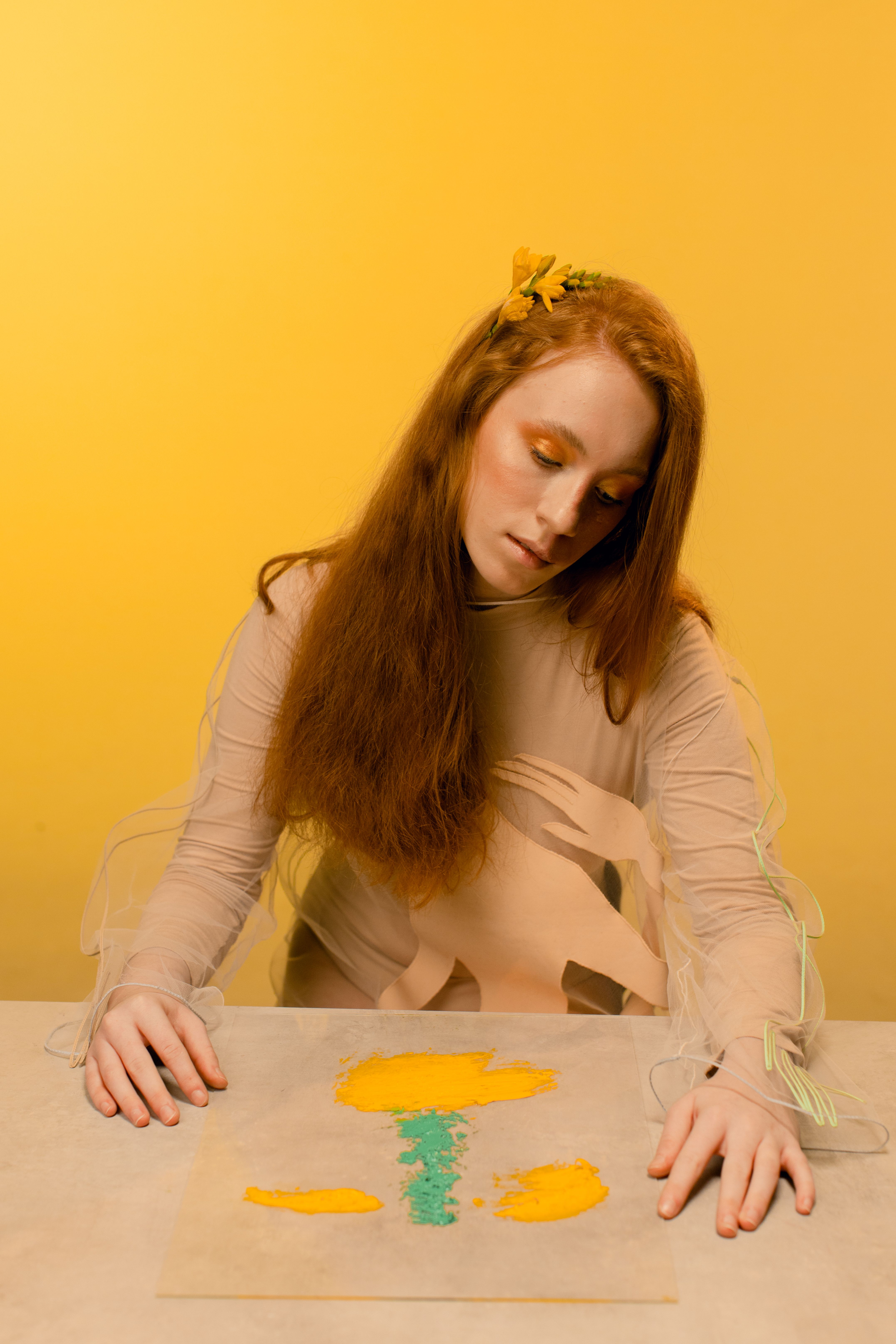 Captivating image of a woman artistically posed, immersed in creativity with a yellow background.