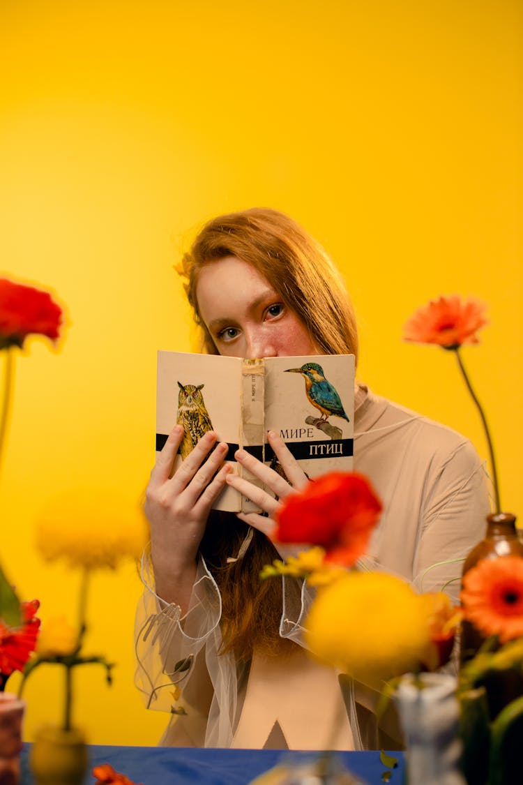 Woman Covering Mouth With A Book