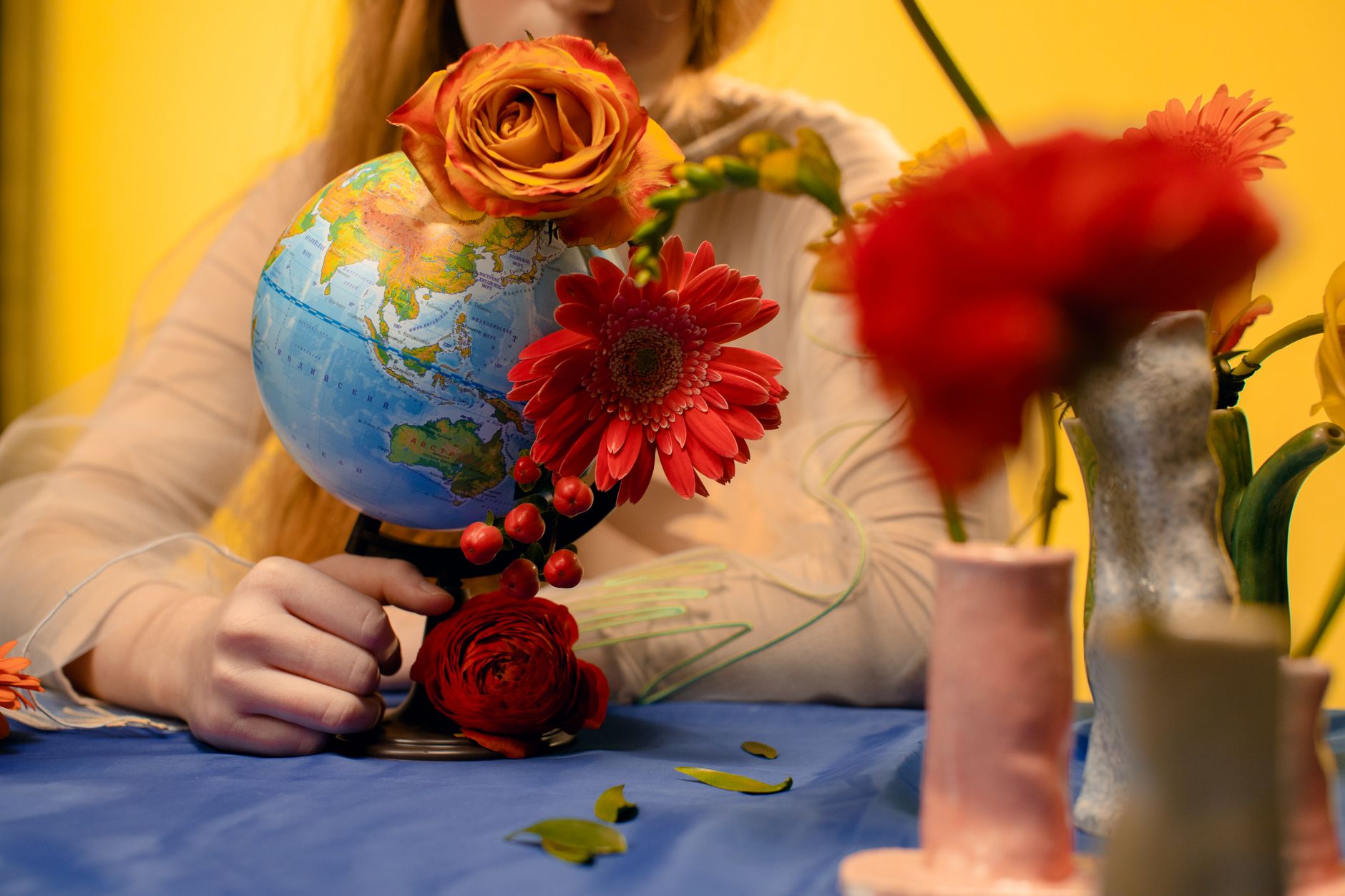 Colorful flowers arranged around a globe creates a harmonious and artistic scene.