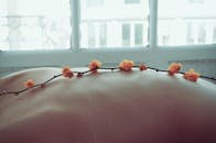 在轻松的温泉场景中，皮肤上微妙的花朵呈现出柔和的散景效果