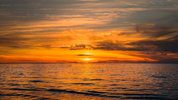 Stunning golden sunset over a calm ocean, capturing nature's serene beauty and vibrant horizons.
