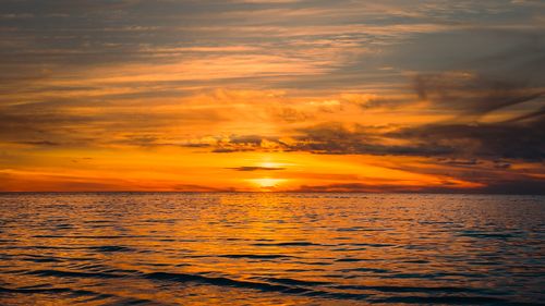 Free Stunning golden sunset over a calm ocean, capturing nature's serene beauty and vibrant horizons. Stock Photo