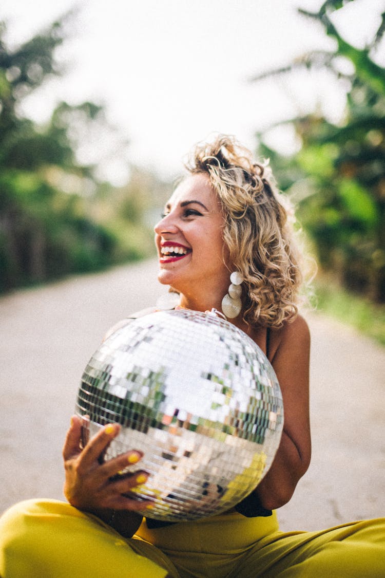 A Woman Holding A Mirror Ball