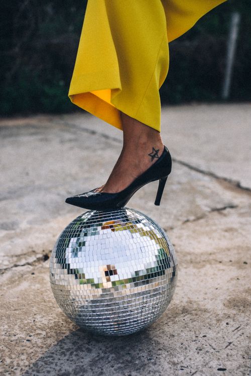 Free Stylish black high heel on a disco ball outdoors, showcasing modern fashion and lifestyle. Stock Photo