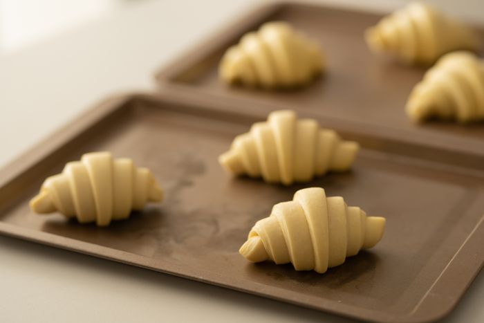 Rolled croissant dough resting before baking, photo by Cats Coming on Pexels