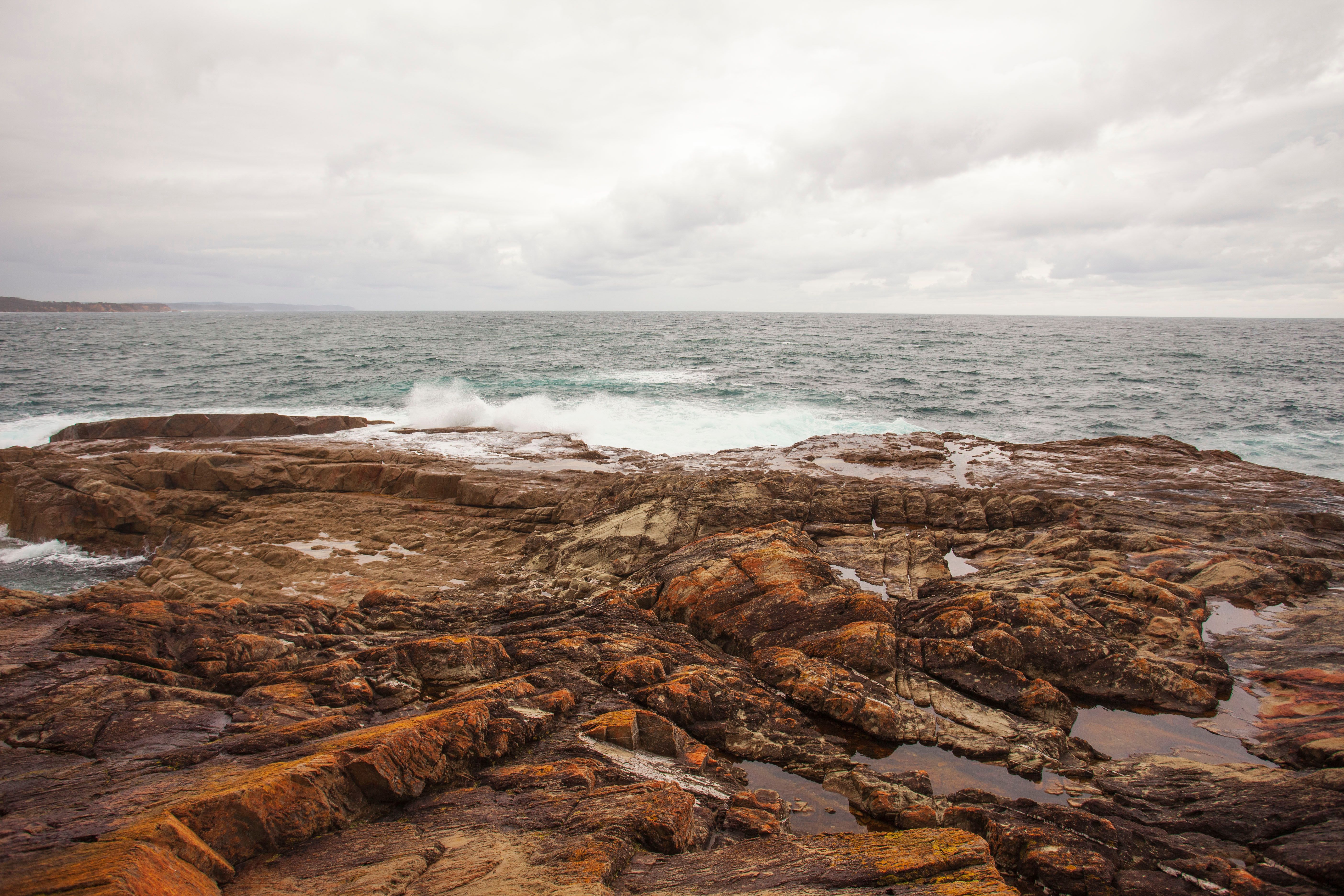 Brown Rock Formation Near Body of Water · Free Stock Photo