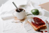 A Cup of Coffee Beside a Plate with Bread