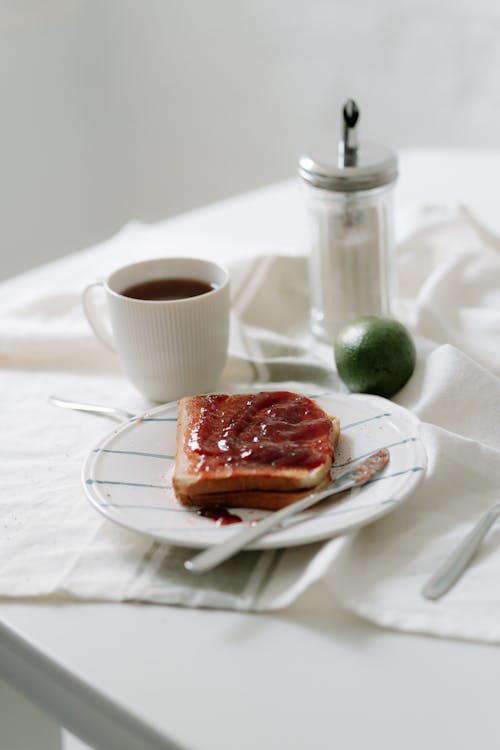 Toasts with Jam on Plate Next to a Cup of Black Coffee