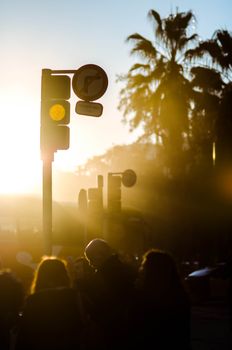 Silhouette of people under traffic lights during sunset in Barcelona, Spain.