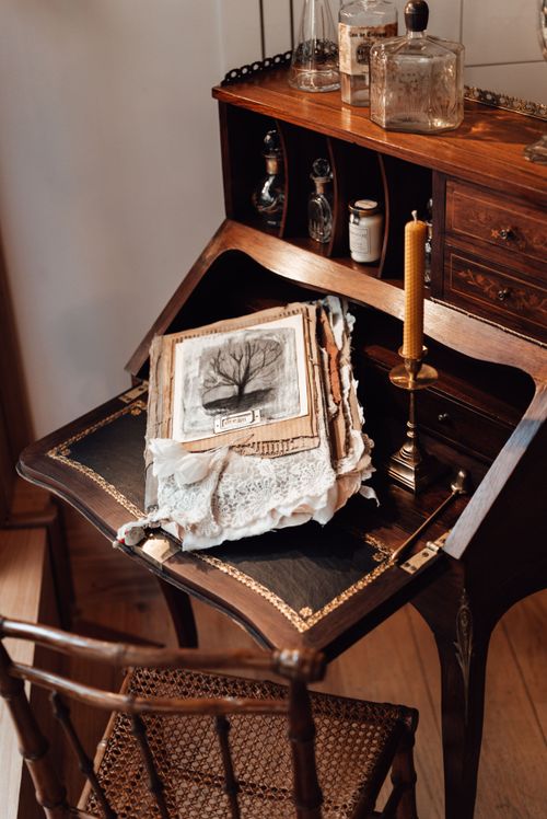 Free An antique writing desk with old books, a wax candle, and decorative bottles for a nostalgic, vintage feel. Stock Photo