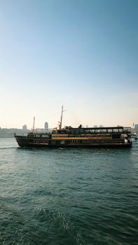 A classic ferry travels across a calm blue sea under a clear sky, perfect for coastal travel inspiration.