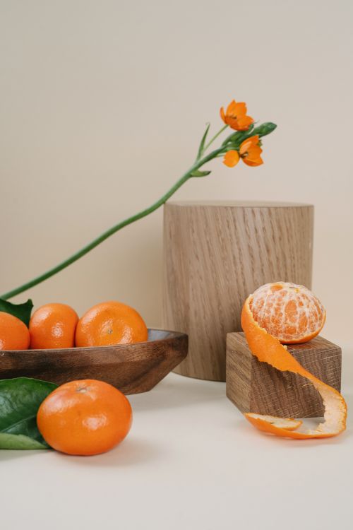 Free A beautifully arranged still life of vibrant tangerines and delicate orange blossoms with wooden textures. Stock Photo
