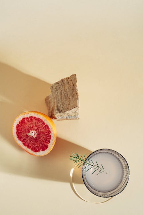 Overhead Shot of a Slice of Grapefruit Beside a Rock