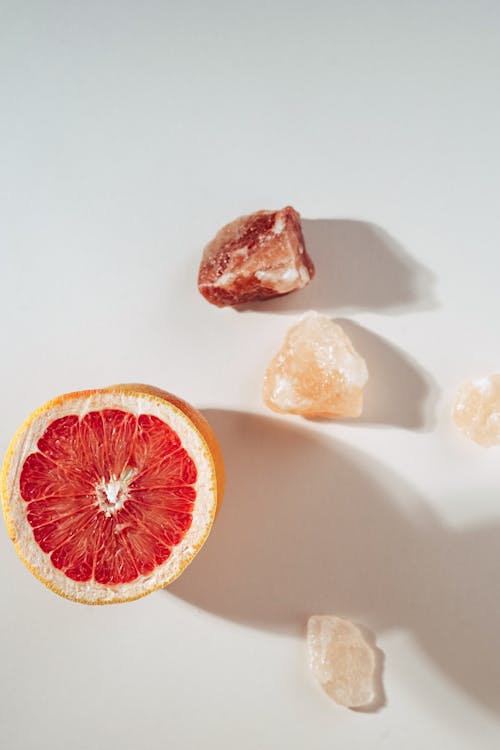 
A Sliced Grapefruit and Stones