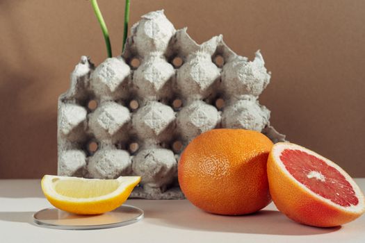 A creative composition of citrus fruits and an egg carton for a rustic aesthetic.