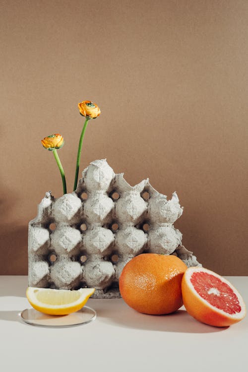 Citrus Fruits beside an Egg Tray