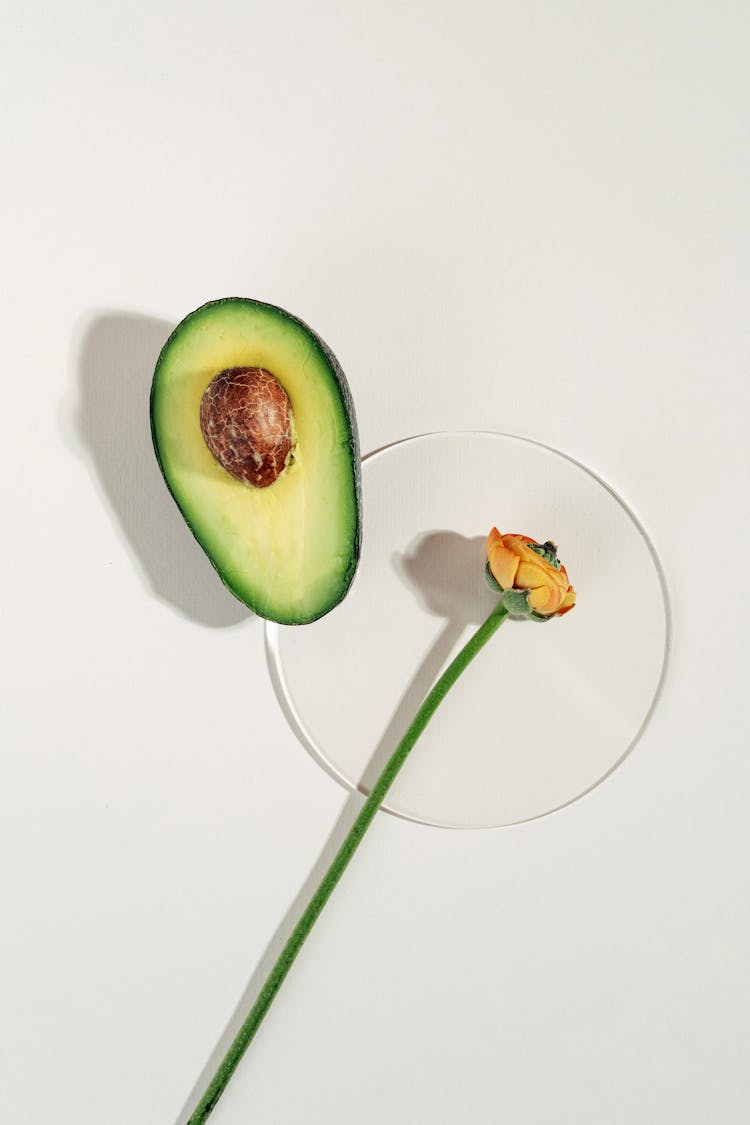 Sliced Avocado And Yellow Flower On Clear Plate