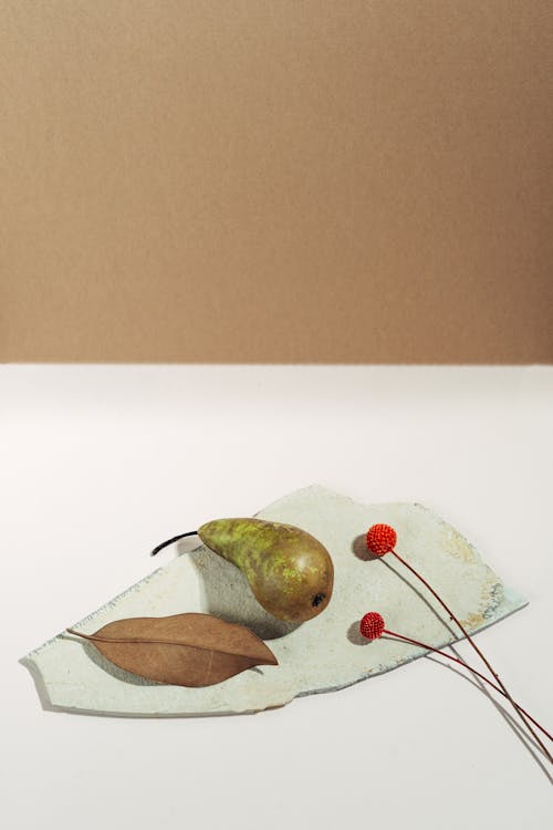 Free Top View of a Pear beside Flowers and a Leaf Stock Photo