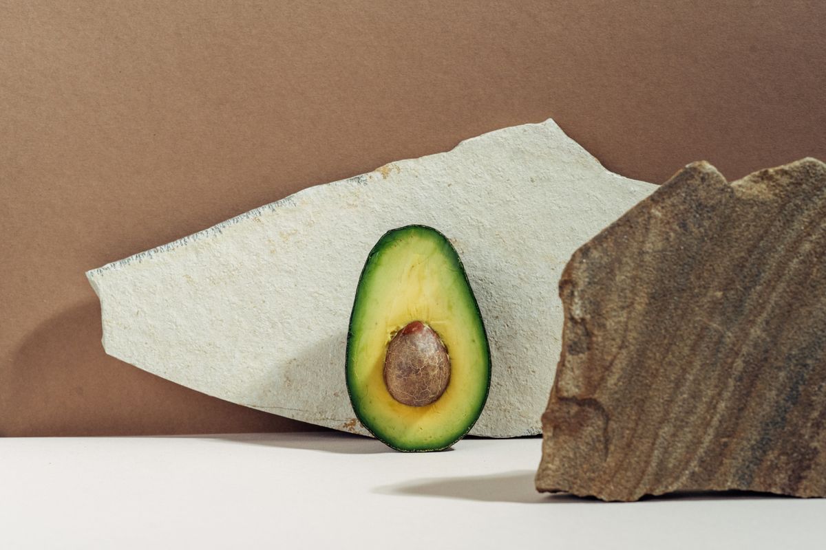 Halved avocado on a warm textured surface — photo by Ivan S on Pexels