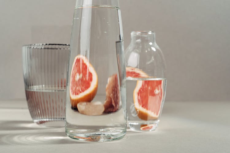 Glass Bottles With Sliced Orange In The Background