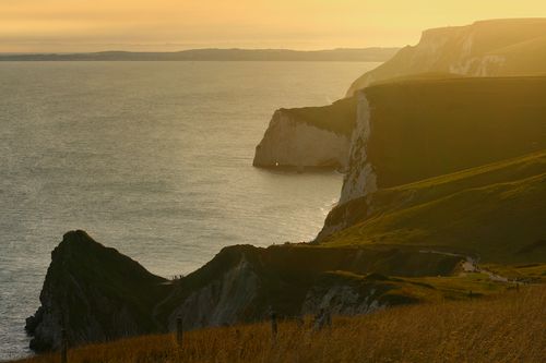 Free Breathtaking view of the Jurassic Coast cliffs and ocean at sunset, showcasing natural beauty. Stock Photo