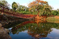 在印度贾巴尔普尔，湖畔的桥梁和树木倒映在水中，呈现出一片宁静的景象