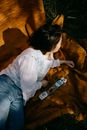 Girl in White Long Sleeve Shirt and Blue Denim Jeans Sitting on Brown Sofa