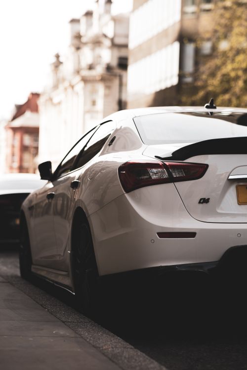 Free Stylish white sedan parked on a street in Manchester, England, showcasing urban life. Stock Photo