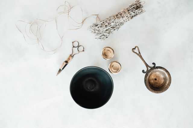 Small brass dishes and snuffer arranged on a pale stone surface — furkanfdemir on Pexels