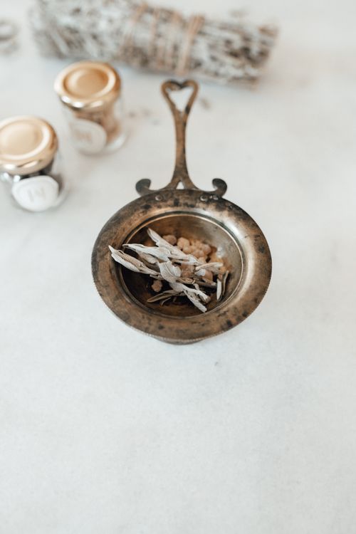 Free A close-up of a vintage brass container holding dried herbs and spices on a white background. Stock Photo