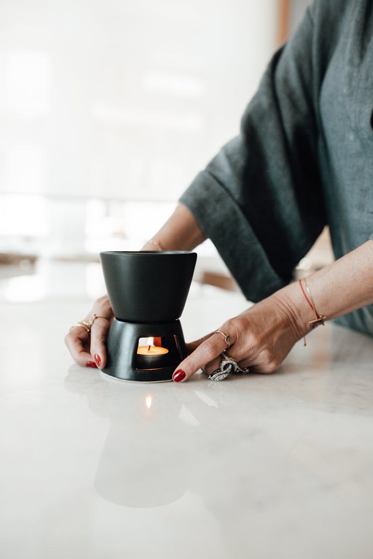 Woman Hands Holding Mug With Wax Candle