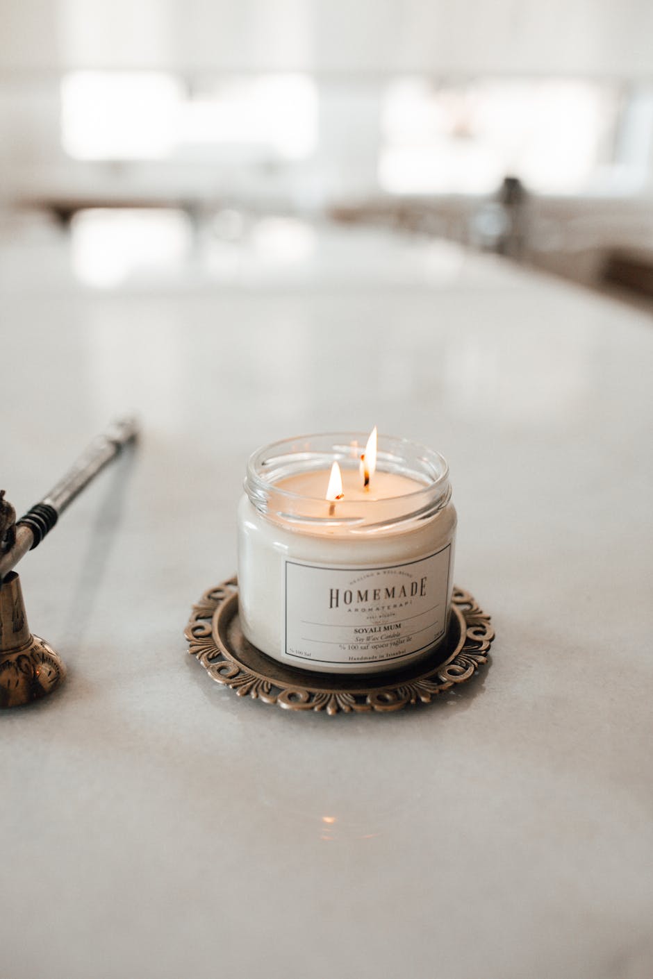 A beautifully lit homemade scented candle on a decorative tray, exuding a warm ambiance.