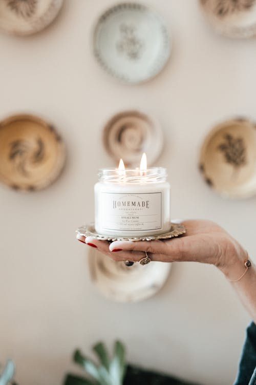 Woman Hand Holding Candle in Jar