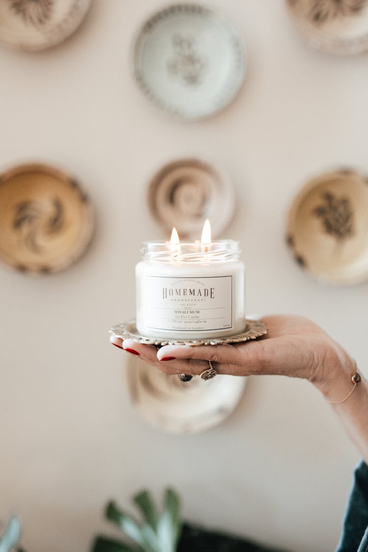 Woman Hand Holding Candle In Jar