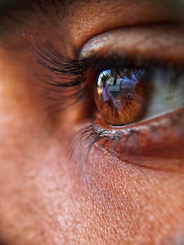 Detailed close-up of a brown eye reflecting a scene, showcasing texture and color.