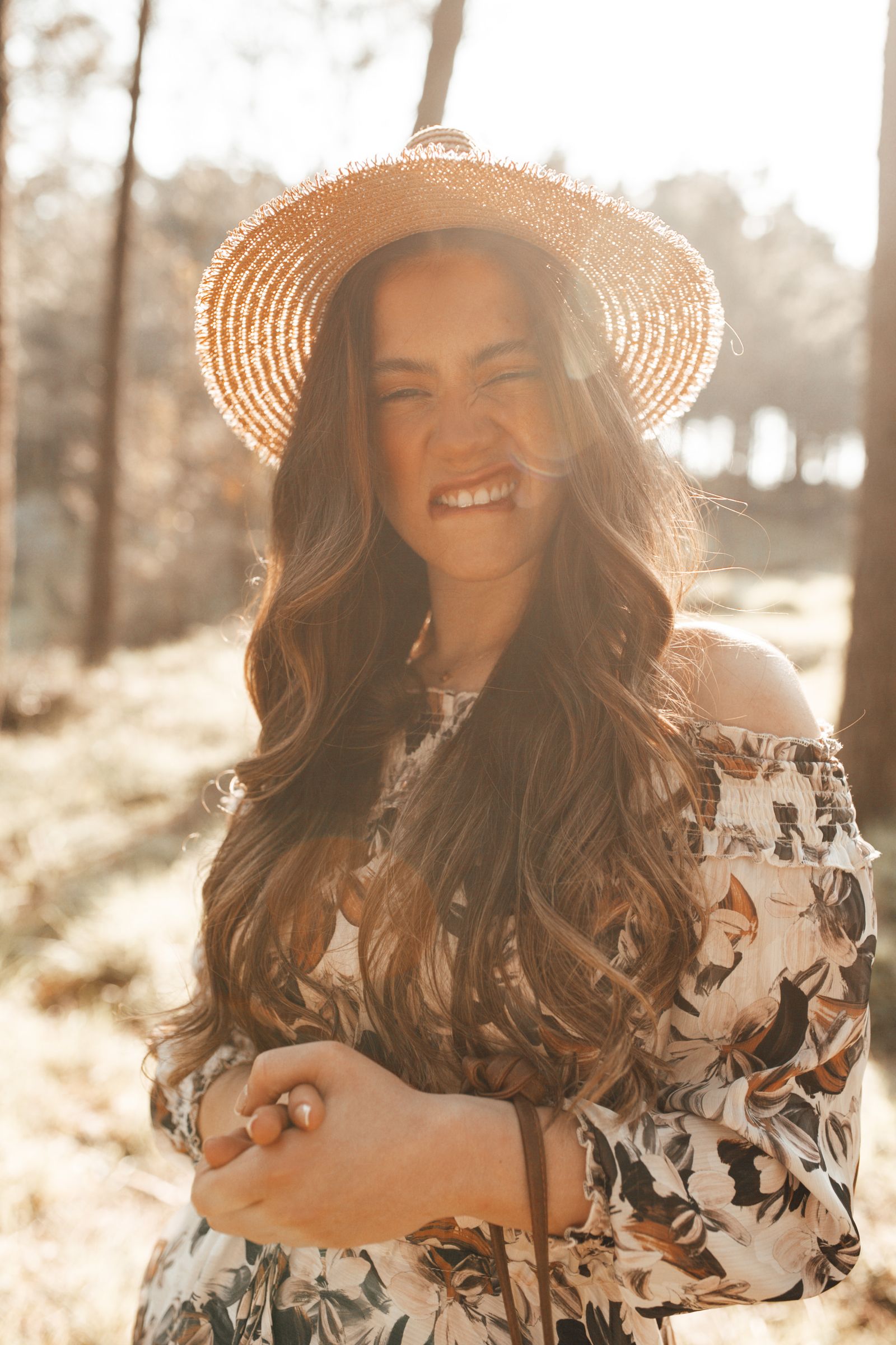 Amara Reyes smiling warmly in golden light, wearing a straw hat and floral dress