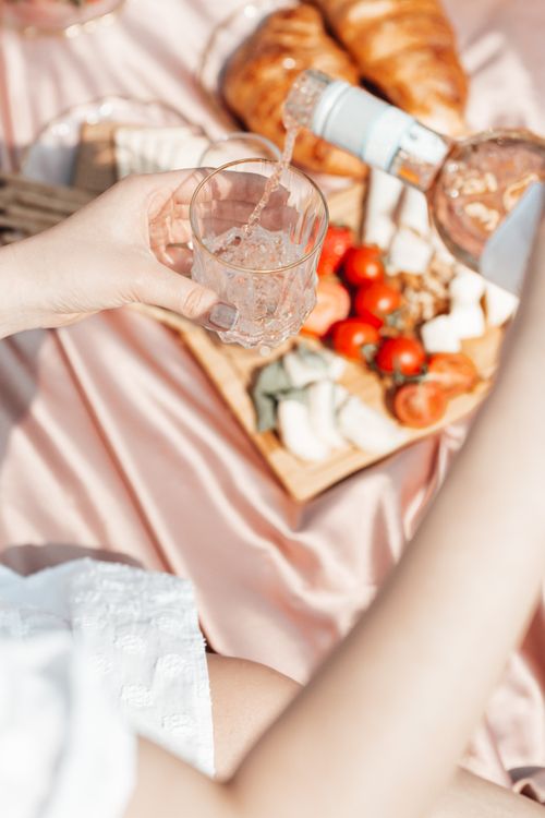 Free Woman pours drink on a picnic with fresh food on a sunny day. Stock Photo