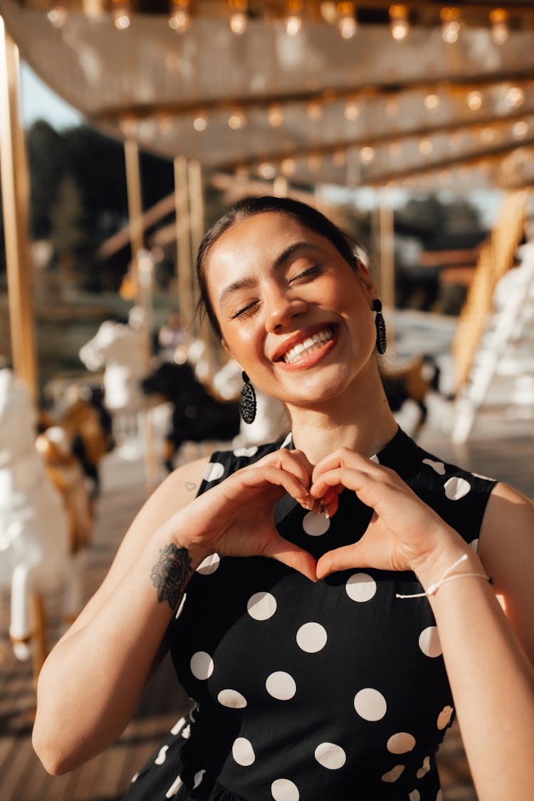 Smiling Woman Making Heart Gesture With Hands