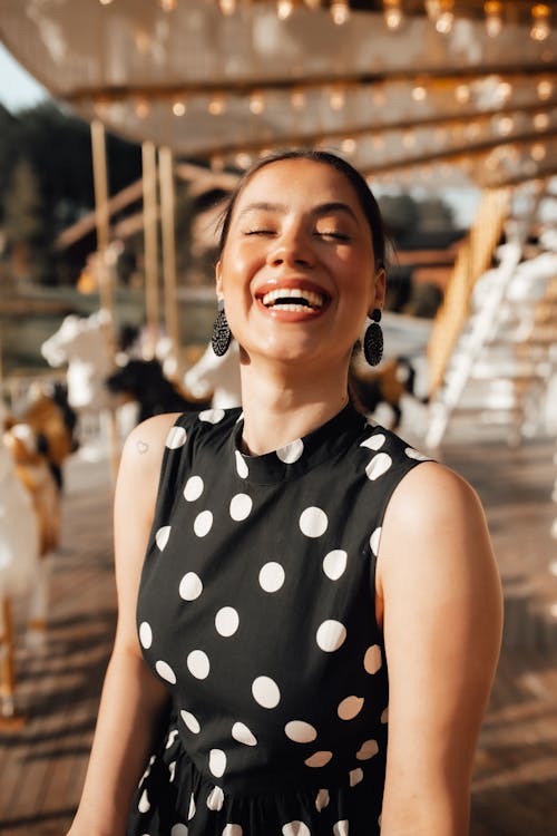 Free Woman in Black and White Polka Dot Dress Smiling Stock Photo