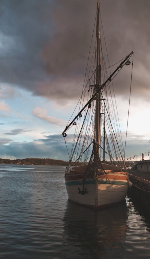 A Sailboat on Body of Water Near Dock