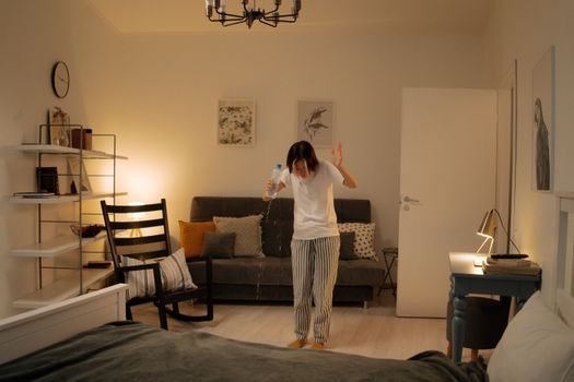 Photograph of a Woman Spilling Water in Her Bedroom