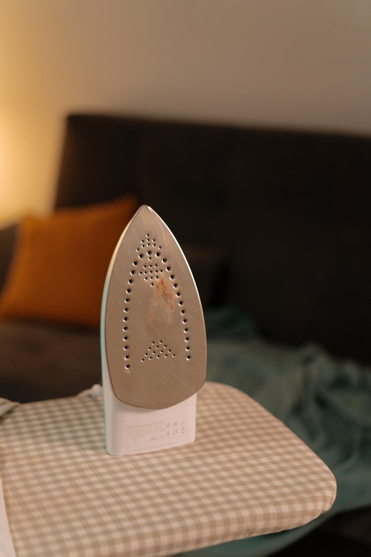 A Clothes Iron On An Ironing Board