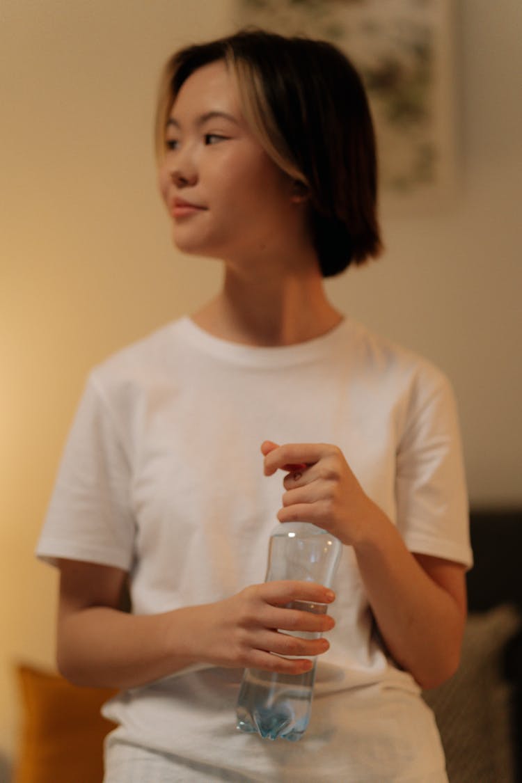 A Young Woman Opening A Water Bottle