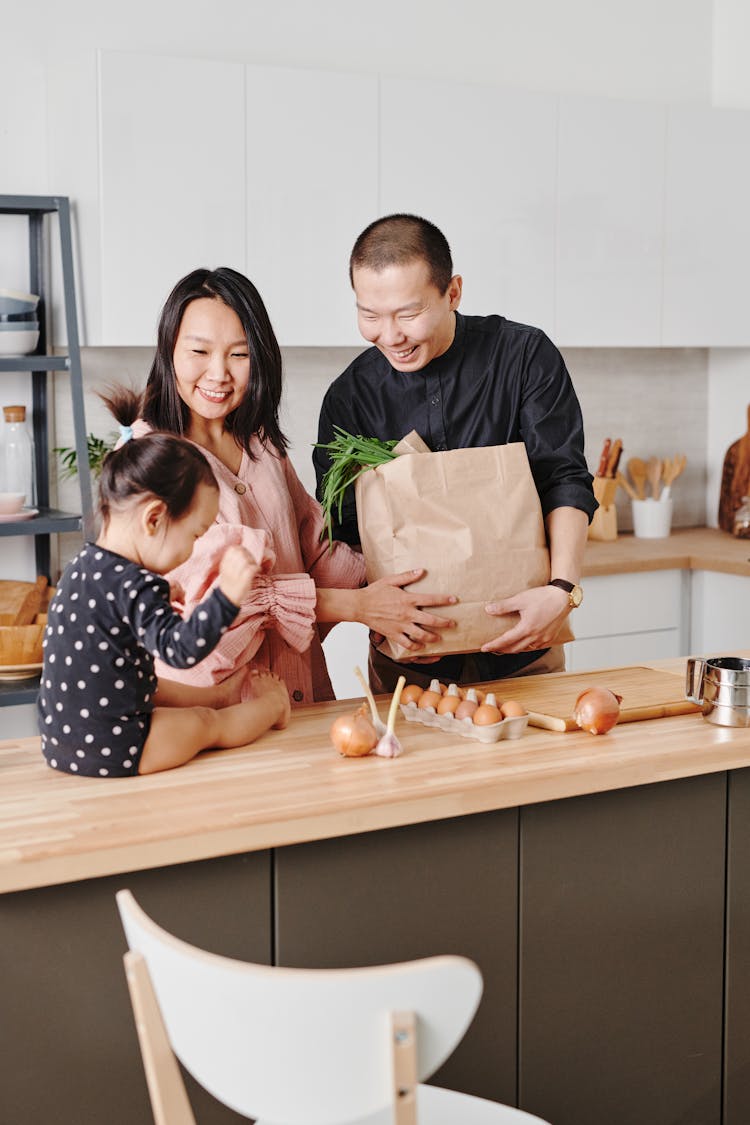 Couple Standing At Counter With Their Baby