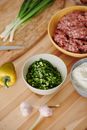 A Bowl of Chopped Scallions Near a Bowl of Minced Meat
